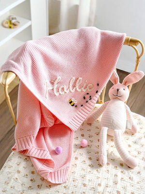 Pink knit baby blanket embroidered with Hallie and a bee