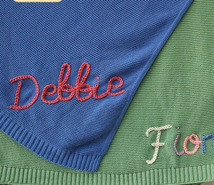 Blue and green knit blankets embroidered with Debbie and Fiona in yarn