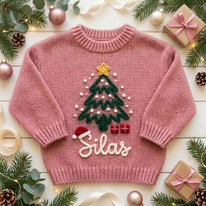 Personalized Christmas sweater with hand embroidered Christmas tree & santa hat among Christmas decorations