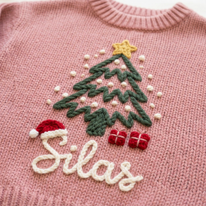 Close-up of hand embroidered Christmas tree & santa hat on chunky knit