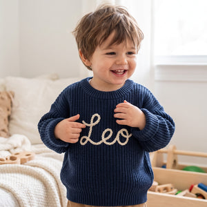 Toddler wearing a personalized hand embroidered name sweater