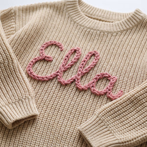 Close-up of hand embroidered chain stitch name on chunky knit