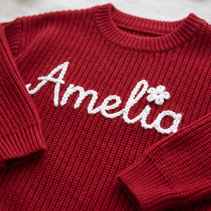 Close-up of hand embroidered chain stitch name on chunky knit