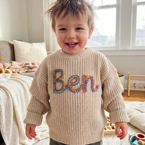 Toddler wearing a personalized hand embroidered name sweater