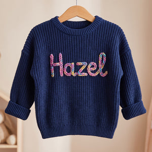 Personalized kids sweater on a wooden hanger