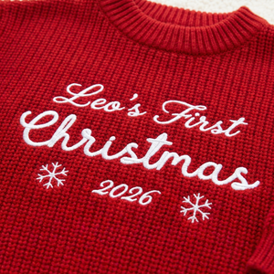 Close-up of machine embroidered first Christmas script on chunky knit