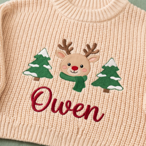 Close-up of machine embroidered reindeer & Christmas trees on chunky knit