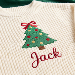 Close-up of machine embroidered Christmas tree with bow topper on chunky knit