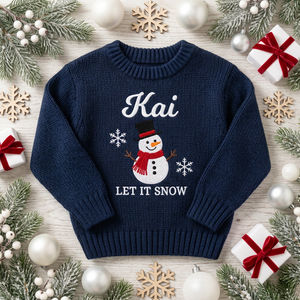 Machine embroidered snowman Let It Snow baby Christmas sweater among Christmas decorations