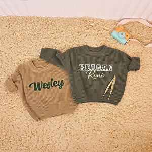 Tan and olive knit sweaters embroidered with Wesley and Reagan René