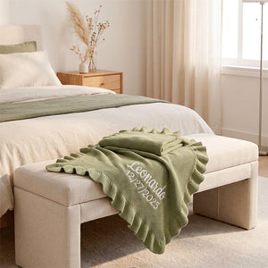 Olive ruffle knit blanket embroidered with Leonida on a bench