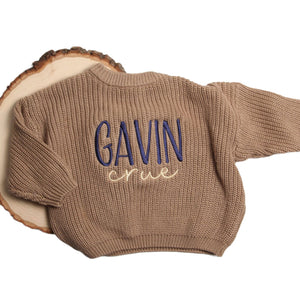 Brown knit baby sweater with an embroidered name in navy and cream