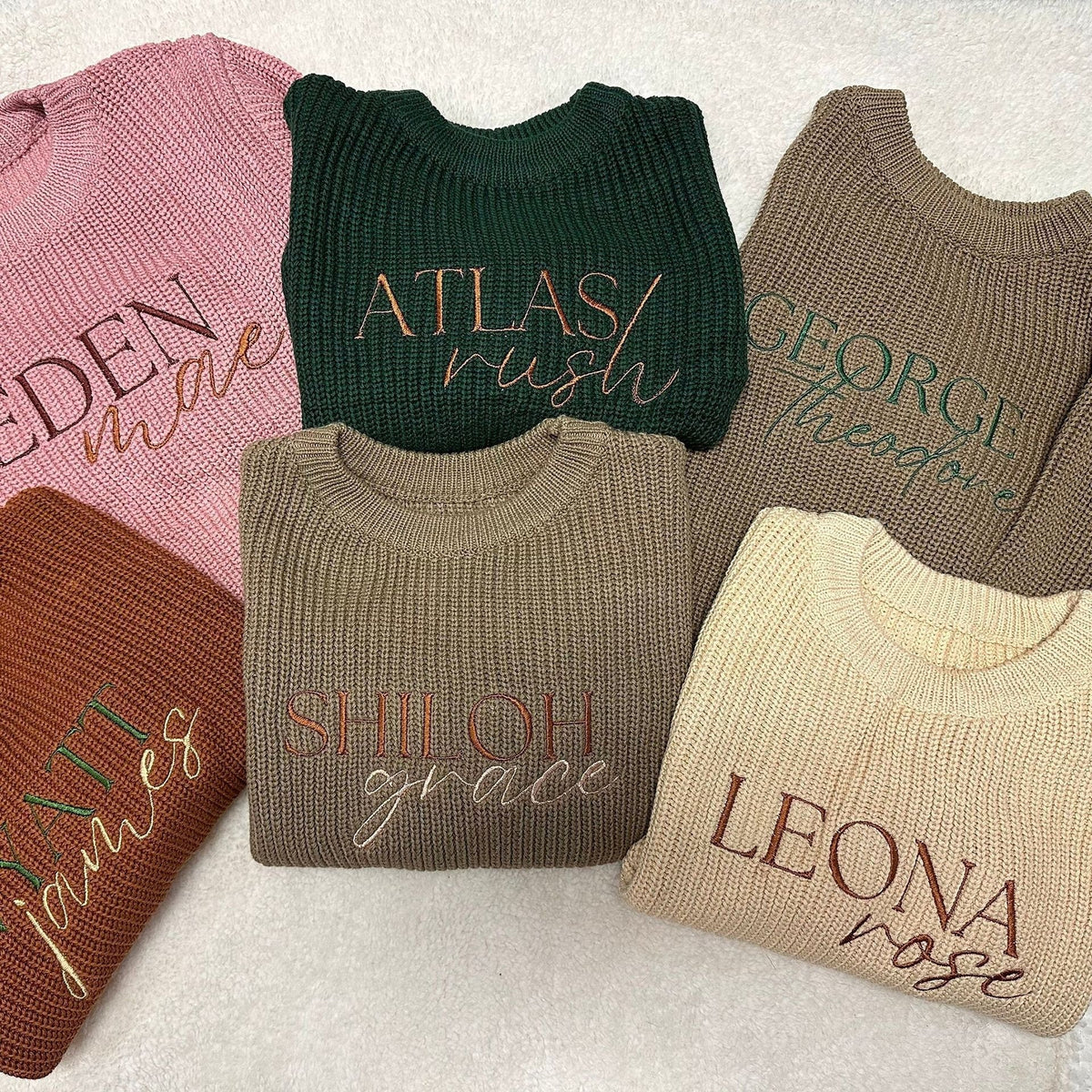 Assorted personalized knit sweaters with embroidered first and middle names