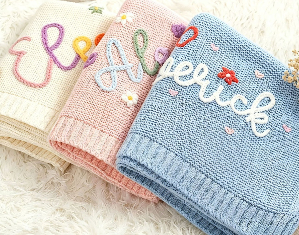Knit blankets embroidered with colorful yarn names and flowers