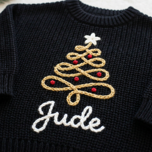 Close-up of hand embroidered gold swirl Christmas tree on chunky knit
