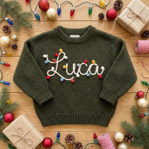 Personalized Christmas sweater with hand embroidered string lights name among Christmas decorations