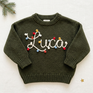 Personalized baby Christmas sweater, hand embroidered string lights name, flat lay