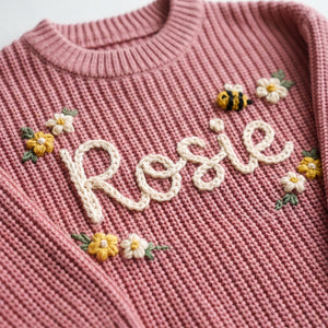 Close-up of hand embroidered chain stitch name on chunky knit