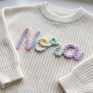 Close-up of hand embroidered chain stitch name on chunky knit