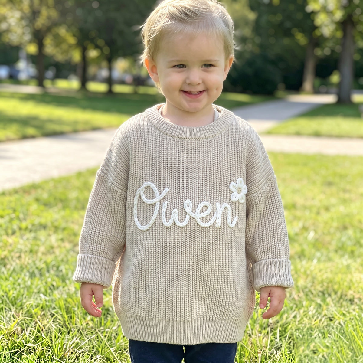 Toddler wearing a personalized hand embroidered name sweater