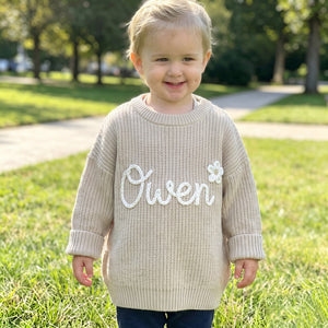 Toddler wearing a personalized hand embroidered name sweater