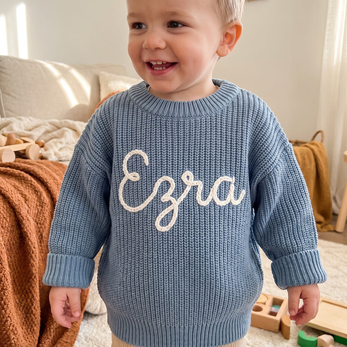 Toddler wearing a personalized hand embroidered name sweater