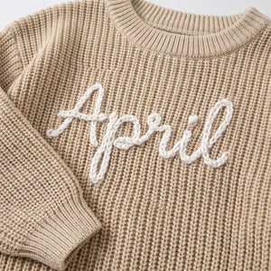 Close-up of hand embroidered chain stitch name on chunky knit