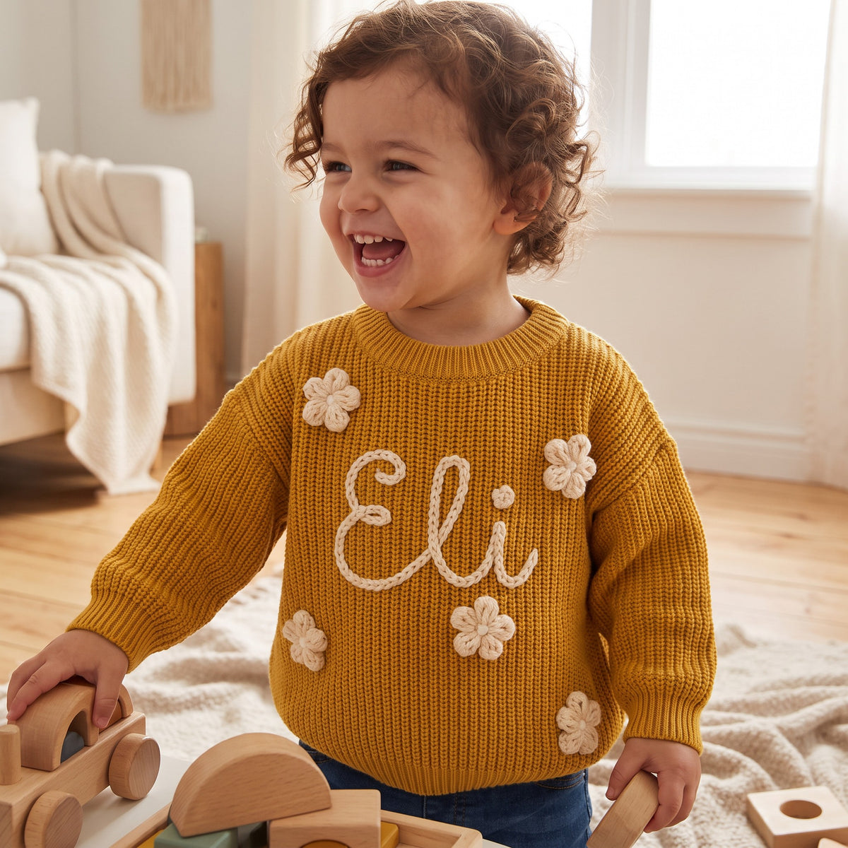 Toddler wearing a personalized hand embroidered name sweater