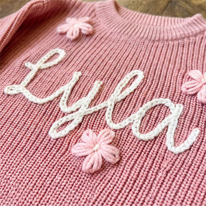 Close-up of hand embroidered chain stitch name on chunky knit