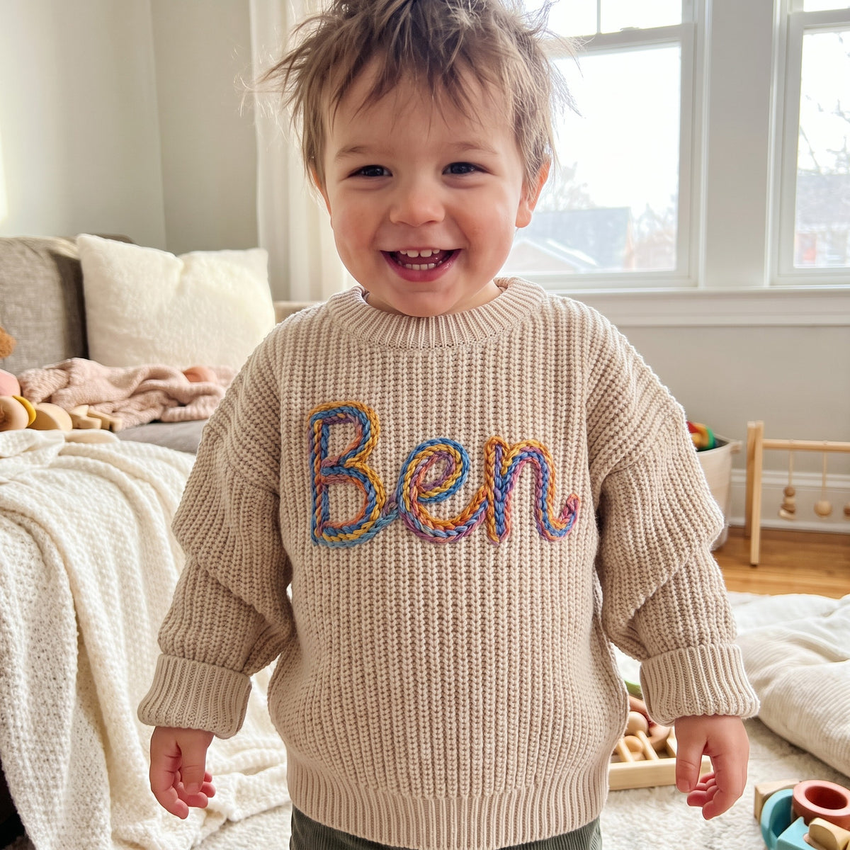 Toddler wearing a personalized hand embroidered name sweater