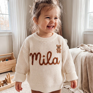 Toddler wearing a personalized hand embroidered name sweater