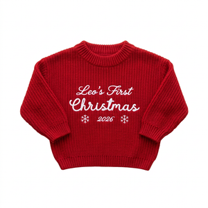 Machine embroidered first Christmas script baby Christmas sweater on a plain background