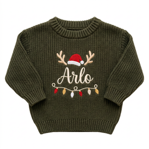 Machine embroidered reindeer antlers, Santa hat & lights baby Christmas sweater on a plain background