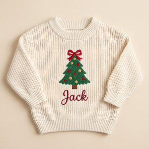 Machine embroidered Christmas tree with bow topper baby Christmas sweater on a plain background