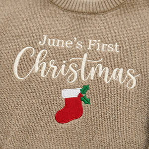 Close-up of machine embroidered first Christmas stocking on chunky knit