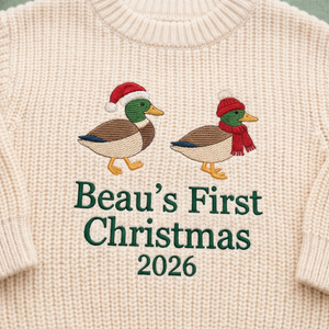 Close-up of machine embroidered first Christmas ducks on chunky knit