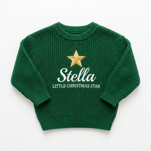 Machine embroidered little Christmas star baby Christmas sweater on a plain background
