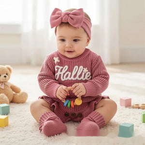 Baby girl in a rose pink knit romper with an embroidered name