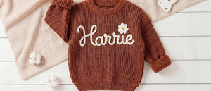 Rust knit kids sweater embroidered with the name Harrie and a daisy