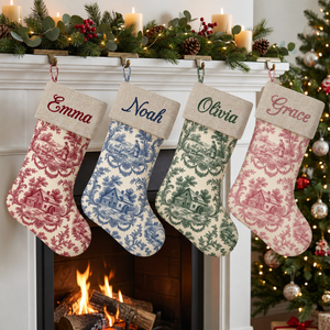 Personalized toile Christmas stockings with natural linen cuff hanging by the fireplace