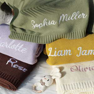 Stack of custom name knit baby blankets with embroidered script names