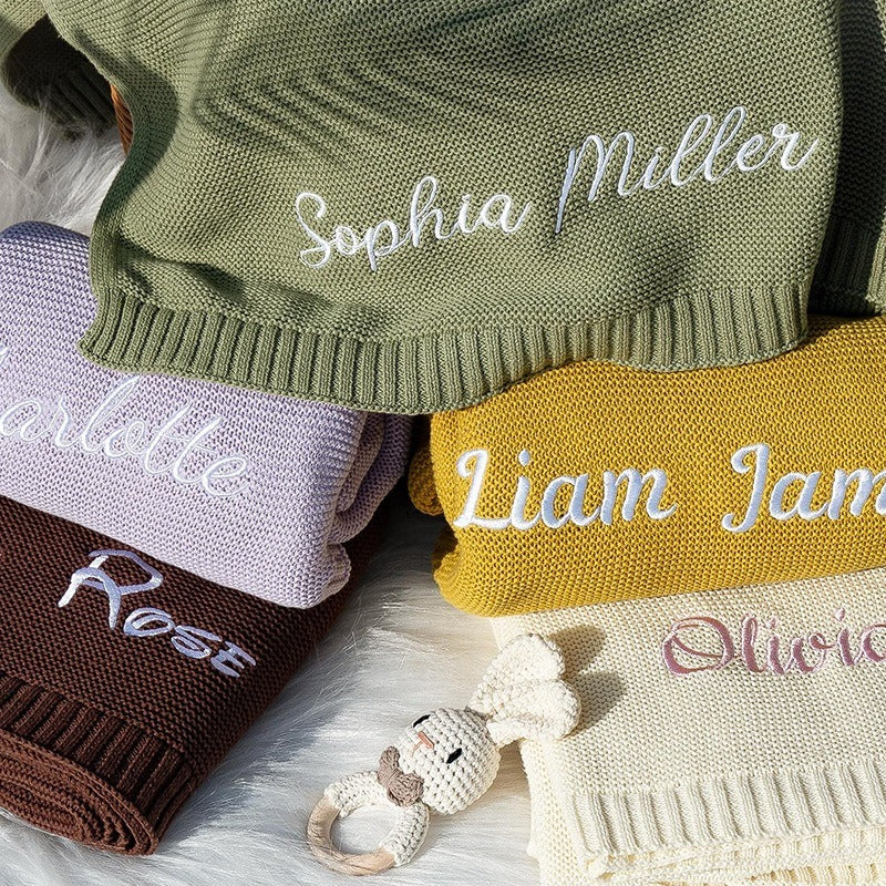 Stack of custom name knit baby blankets with embroidered script names